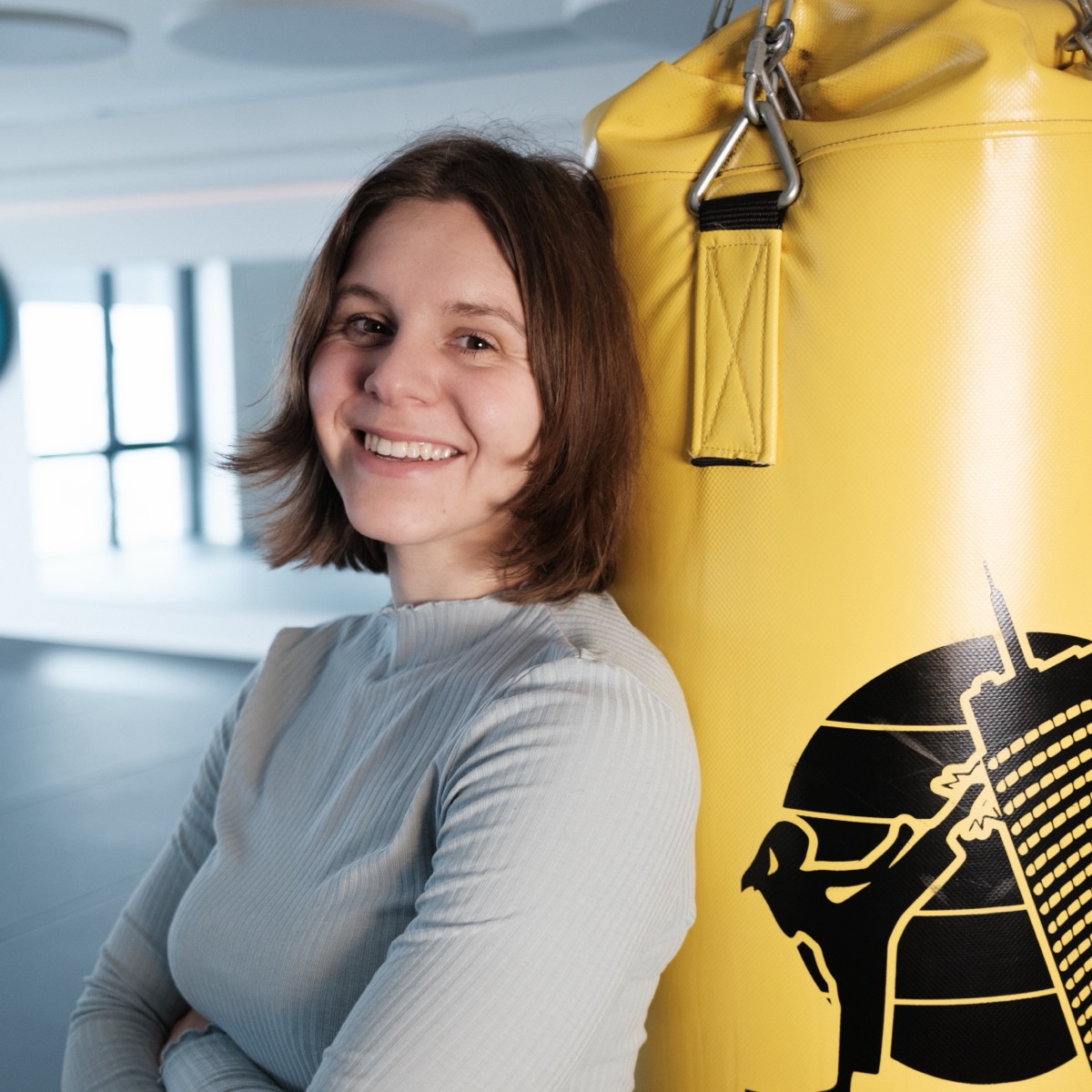 Helena Pagiatakis, Trainerin für therapeutisches Boxen, lächelnd am Sandsack in der KickFit Academy Jena